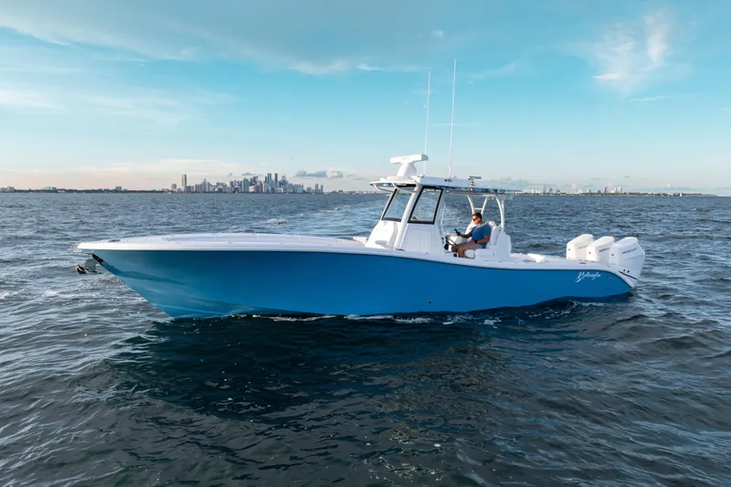  Yacht Photos Pics 2026 Yellowfin 36 Offshore boat cruising on open water with city skyline backdrop.