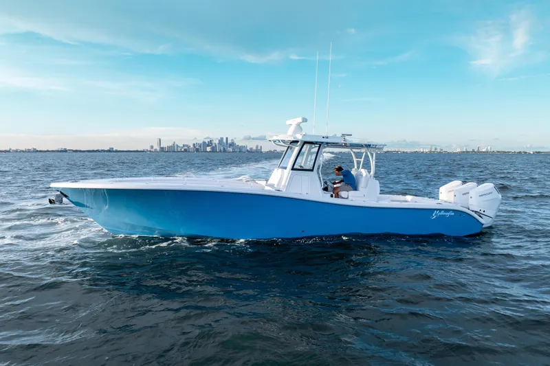  Yacht Photos Pics 2026 Yellowfin 36 Offshore boat cruising on open water with city skyline backdrop.