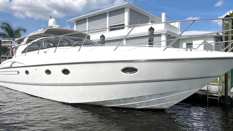 Blind Date Yacht Photos Pics 2005 Viking Princess V50 yacht docked by modern waterfront home.