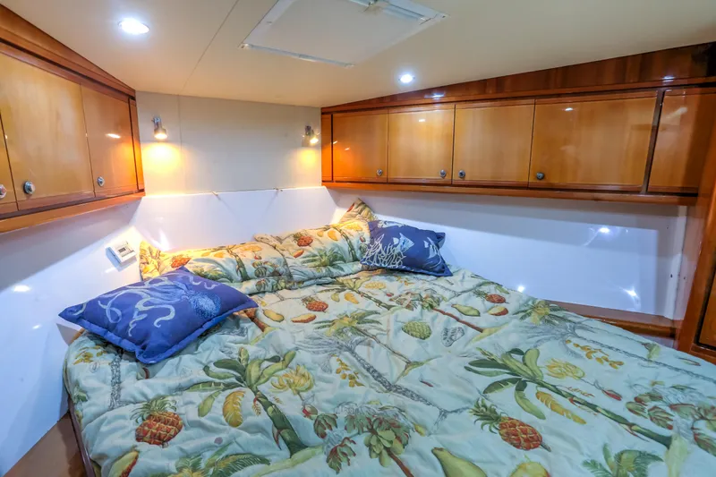  Yacht Photos Pics Cozy bedroom in 2005 Bertram 450 Convertible yacht with floral bedding and wooden cabinets.