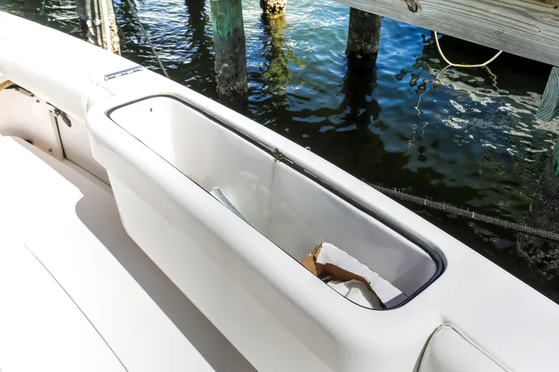  Yacht Photos Pics 2005 Bertram 450 Convertible boat deck with storage compartment by the water.