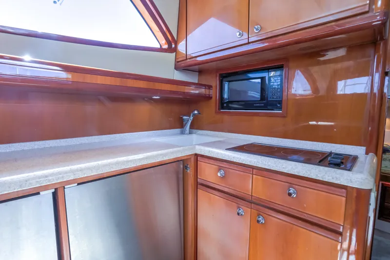  Yacht Photos Pics Luxurious kitchen area in a 2005 Bertram 450 Convertible yacht with wood cabinetry.
