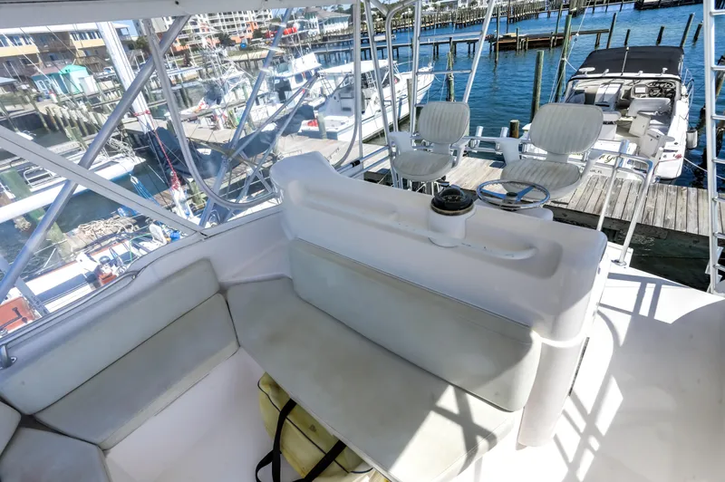  Yacht Photos Pics 2005 Bertram 450 Convertible yacht interior with seating, overlooking marina and boats.