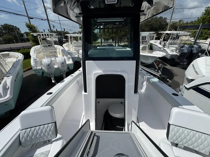  Yacht Photos Pics 2026 Blackfin 262 HB boat interior with seating and console, displayed in a marina.
