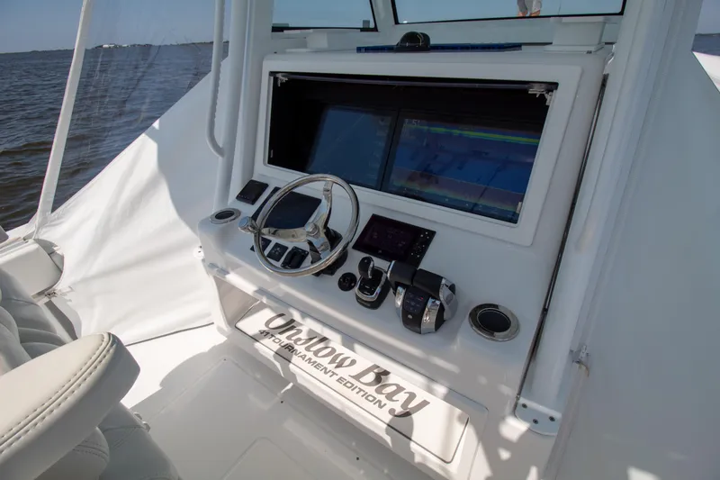 Reel Development Yacht Photos Pics Onslow Bay 41 TE 2022 boat dashboard with steering wheel and navigation screens.