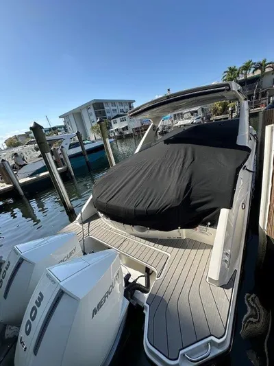  Yacht Photos Pics 2024 Sea Ray SLX 310 OB boat docked with covered seating area and twin Mercury engines.
