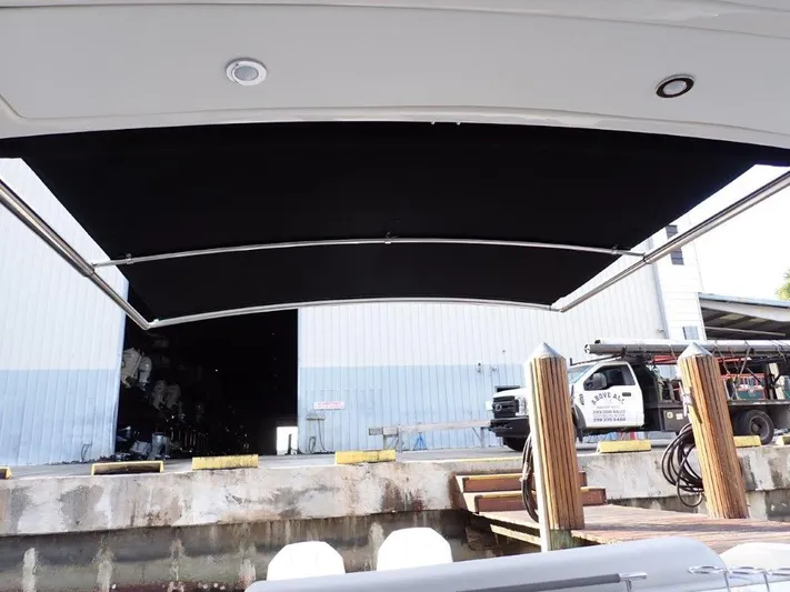  Yacht Photos Pics 2024 Sea Ray SLX 310 OB boat with extended black canopy at dockside.