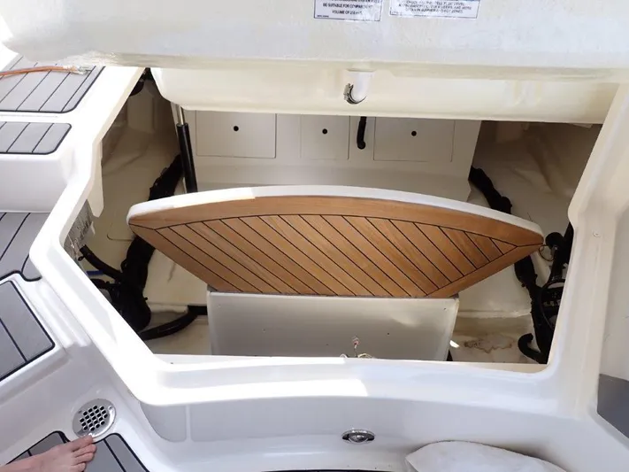  Yacht Photos Pics 2024 Sea Ray SLX 310 OB boat storage compartment with wooden paneling.