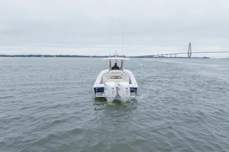  Yacht Photos Pics 2008 Jupiter 31 FS boat on water near a bridge under cloudy skies.