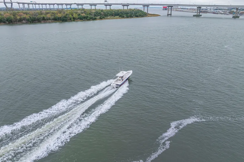  Yacht Photos Pics Aerial view of 2008 Jupiter 31 FS boat cruising on a river near a bridge.