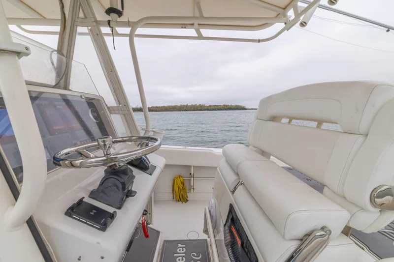  Yacht Photos Pics 2008 Jupiter 31 FS boat interior with steering wheel and seating, overlooking calm waters.