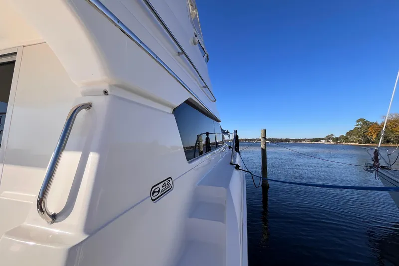  Yacht Photos Pics 2001 Silverton 42C yacht docked by serene waters under clear blue sky.