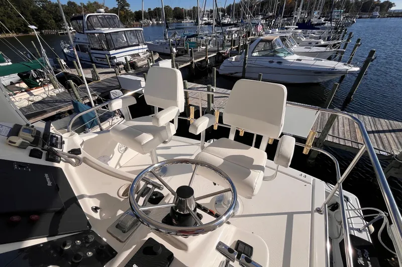  Yacht Photos Pics 2001 Silverton 42C yacht helm with dual white captain chairs at marina.