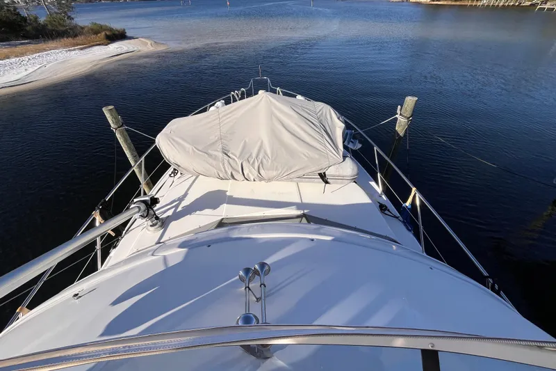  Yacht Photos Pics 2001 Silverton 42C yacht docked in serene waters, covered equipment on deck.