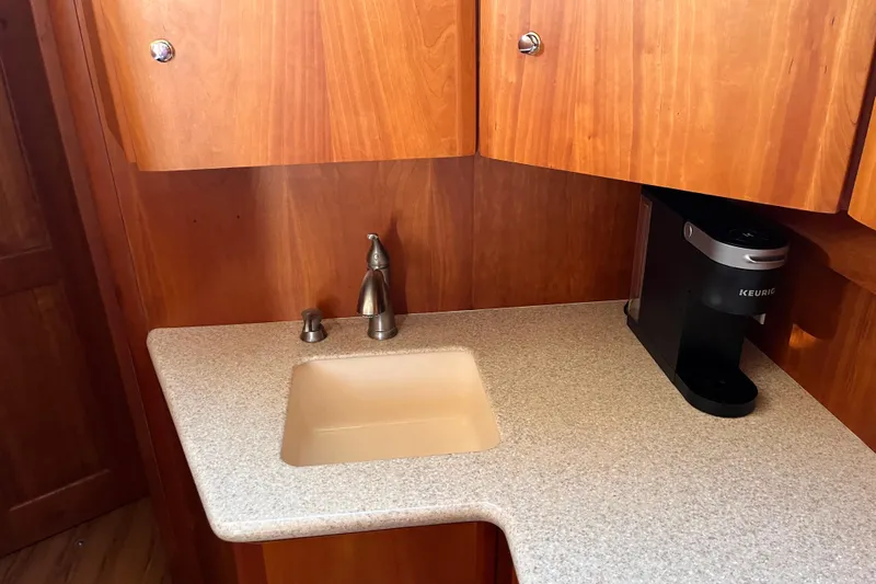  Yacht Photos Pics 2001 Silverton 42C yacht kitchenette with sink, wooden cabinets, and Keurig coffee maker.