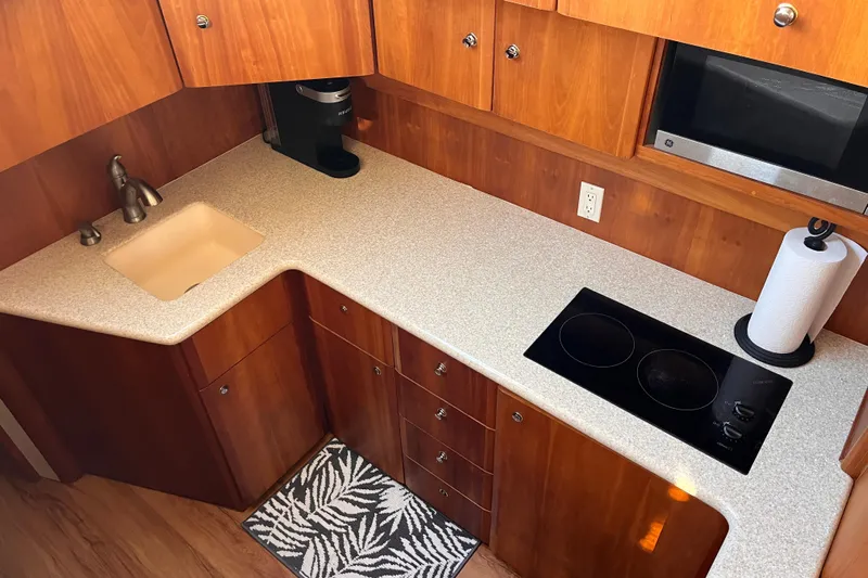  Yacht Photos Pics Modern kitchen in 2001 Silverton 42C yacht with sink, stovetop, and wooden cabinetry.