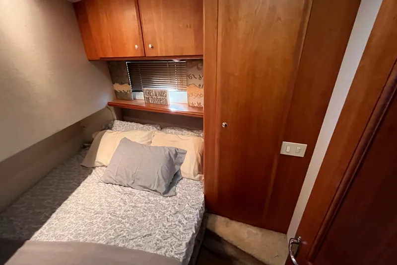  Yacht Photos Pics Cozy bedroom in 2001 Silverton 42C yacht with wooden cabinets and soft bedding.