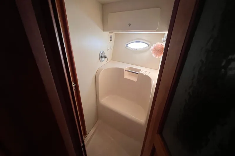  Yacht Photos Pics Compact bathroom in a 2001 Silverton 42C yacht with oval window and shower seat.