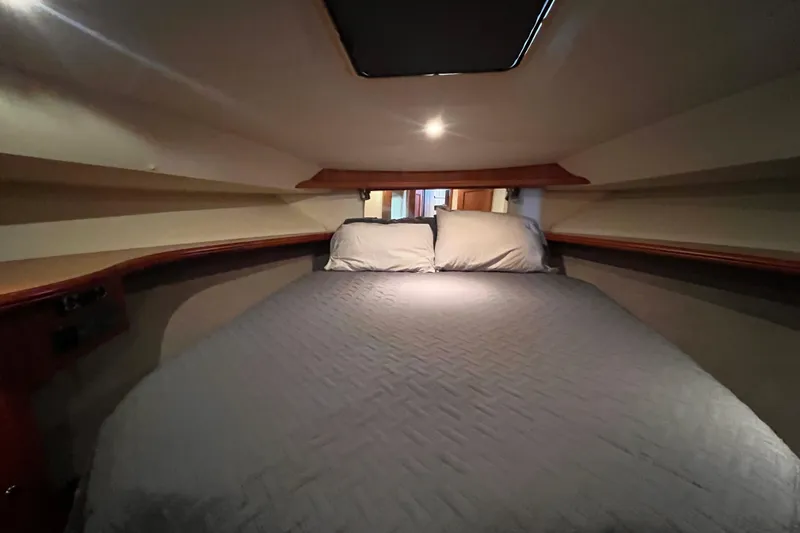  Yacht Photos Pics Cozy cabin bedroom in 2001 Silverton 42C yacht with soft lighting and comfortable bedding.