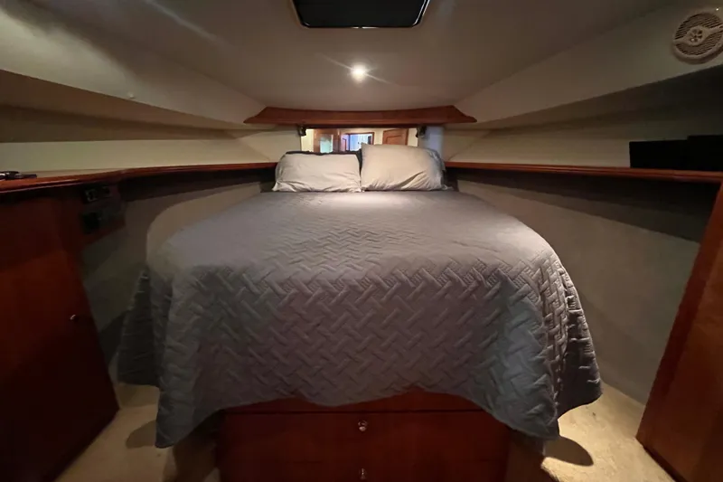  Yacht Photos Pics Interior cabin of 2001 Silverton 42C yacht with cozy bed and wooden accents.