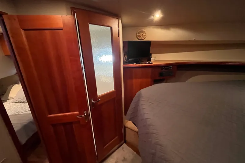  Yacht Photos Pics 2001 Silverton 42C yacht interior with wooden door, bed, and small TV.