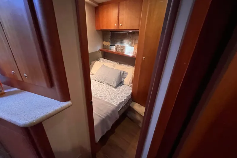  Yacht Photos Pics Cozy bedroom interior of 2001 Silverton 42C yacht with wooden cabinetry and comfortable bedding.