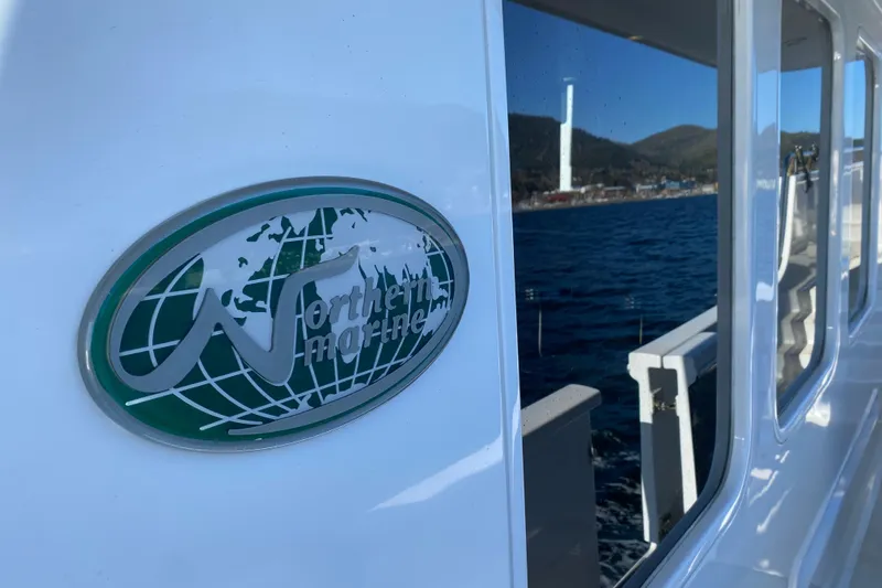 Nomad Yacht Photos Pics Northern Marine 57 Raised Pilothouse yacht, 2003, with logo and ocean view.