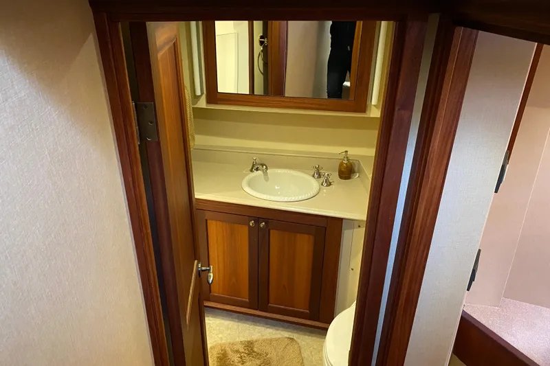 Nomad Yacht Photos Pics Bathroom interior of 2003 Northern Marine 57 Raised Pilothouse yacht, featuring wooden cabinetry.