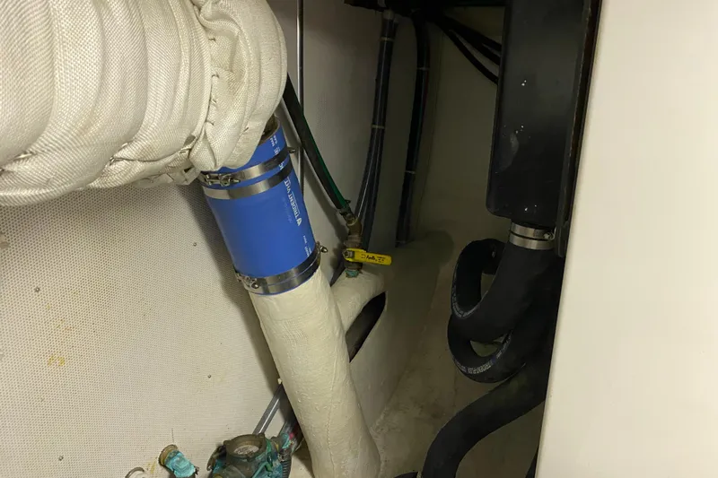 Nomad Yacht Photos Pics Engine room of 2003 Northern Marine 57 Raised Pilothouse with visible piping and hoses.