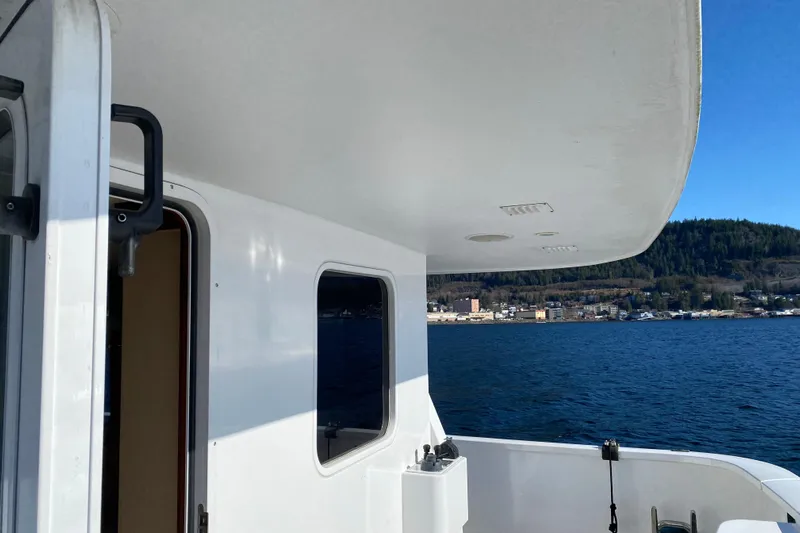 Nomad Yacht Photos Pics 2003 Northern Marine 57 Raised Pilothouse yacht, docked with scenic waterfront view.