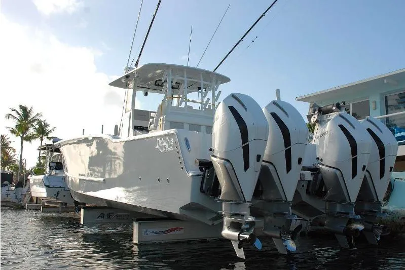  Yacht Photos Pics 2024 Tideline 365 boat with four powerful outboard motors docked in marina.
