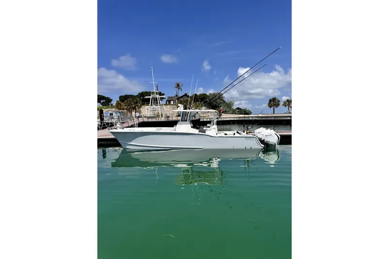  Yacht Photos Pics 2024 Tideline 365 boat docked on calm water under a clear blue sky.