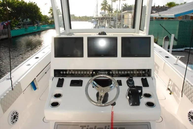  Yacht Photos Pics 2024 Tideline 365 boat dashboard with steering wheel and multiple screens.