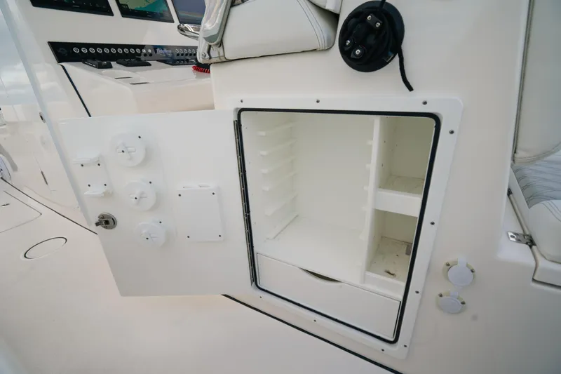  Yacht Photos Pics Open storage compartment on 2024 Tideline 365 boat, showcasing interior shelving and controls.