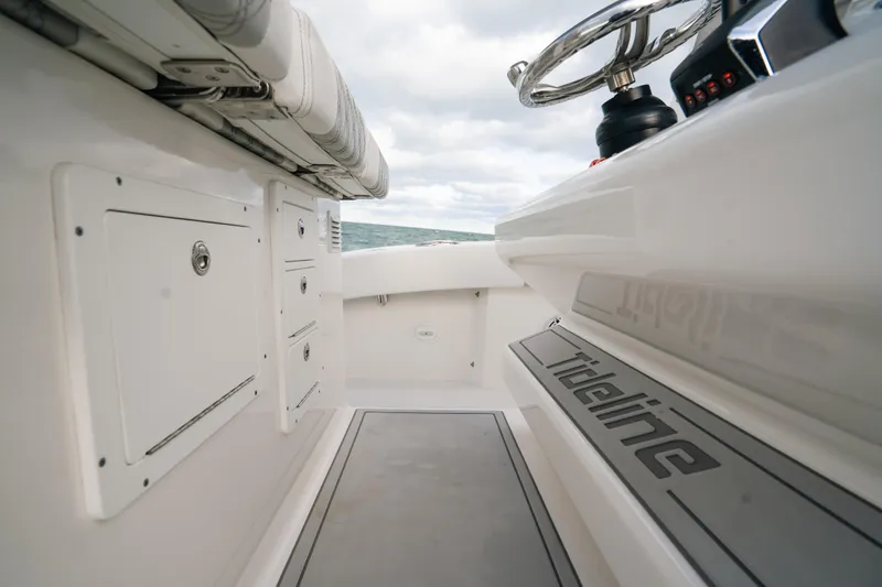  Yacht Photos Pics 2024 Tideline 365 boat interior with steering wheel and storage compartments.
