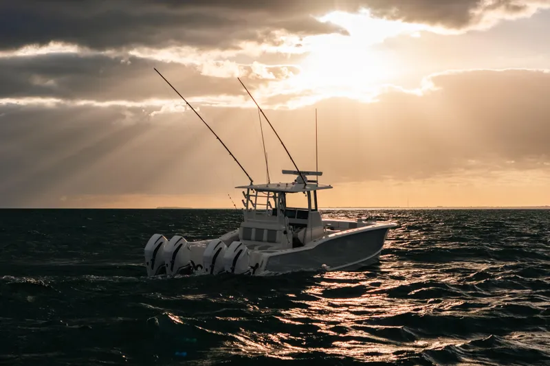  Yacht Photos Pics 2024 Tideline 365 boat on ocean at sunset with fishing rods.