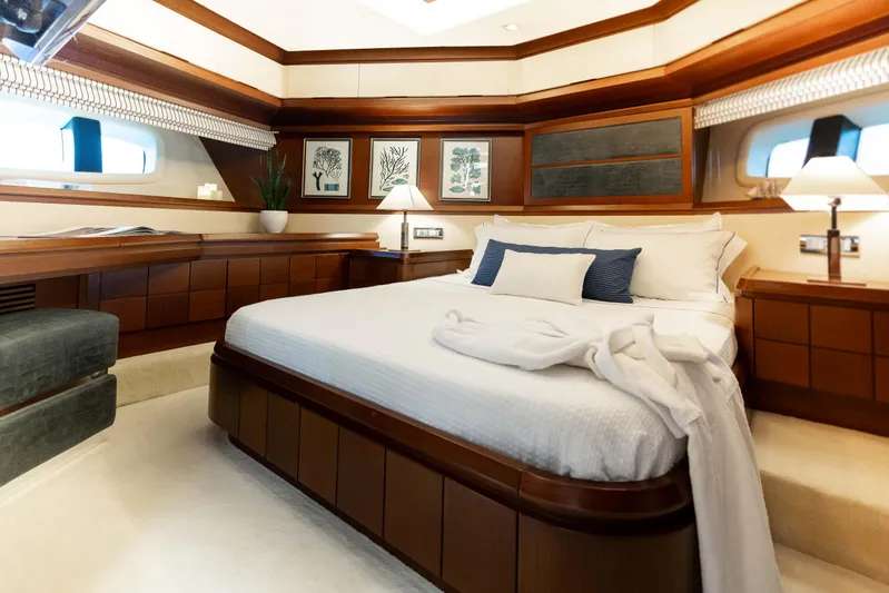 Koukles Yacht Photos Pics Luxurious bedroom interior on 2008 Azimut 95 E yacht, featuring elegant wood finishes and cozy bedding.