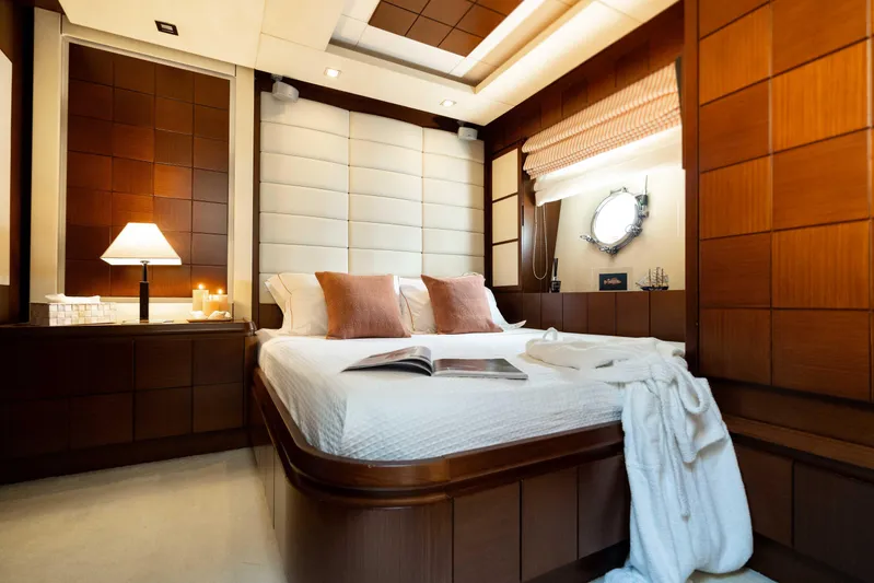 Koukles Yacht Photos Pics Luxurious bedroom interior on 2008 Azimut 95 E yacht, featuring elegant wood paneling and cozy bedding.