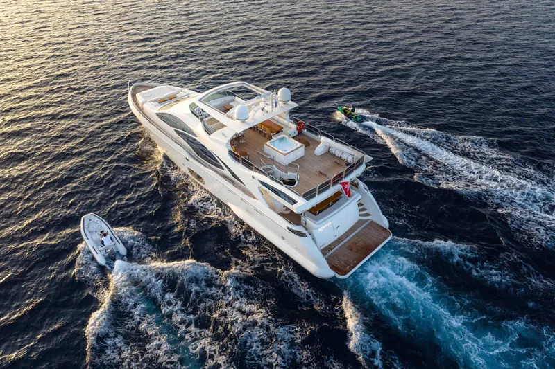 Koukles Yacht Photos Pics Luxurious 2008 Azimut 95 E yacht cruising with jet ski and tender in open sea.
