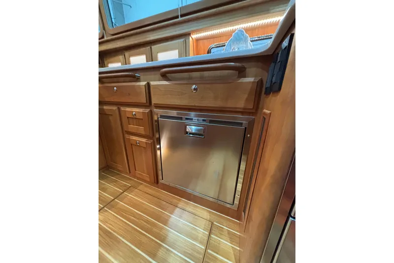 Cellibrate Yacht Photos Pics Interior of 2020 Sabre 45 Salon Express yacht with wooden cabinetry and stainless steel appliance.