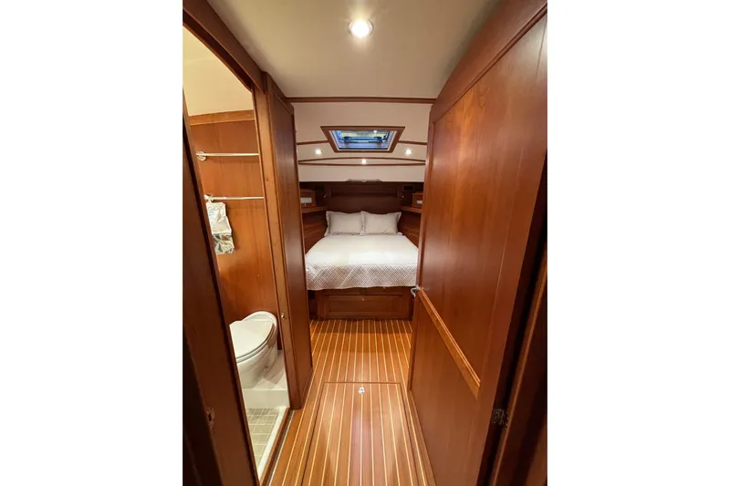 Cellibrate Yacht Photos Pics Luxurious cabin interior of 2020 Sabre 45 Salon Express yacht, featuring wood finishes and cozy bedding.