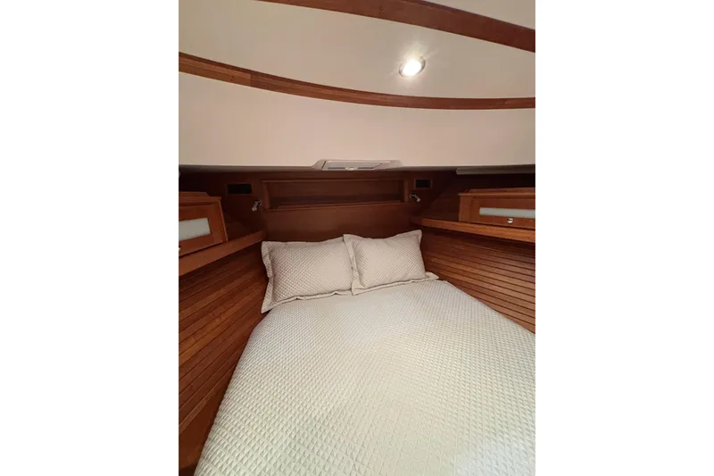 Cellibrate Yacht Photos Pics 2020 Sabre 45 Salon Express cabin with cozy bed and wooden interior.
