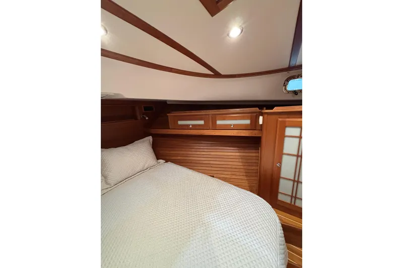 Cellibrate Yacht Photos Pics 2020 Sabre 45 Salon Express cabin with wooden interior and cozy bedding.