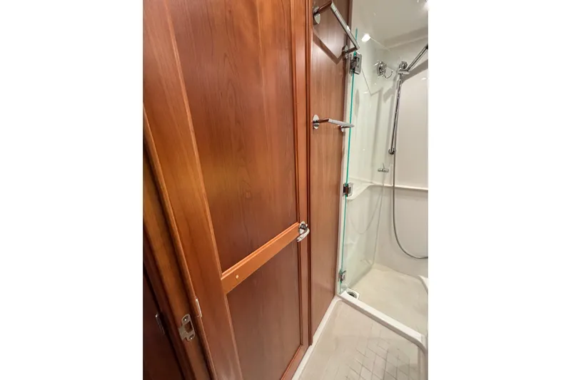 Cellibrate Yacht Photos Pics 2020 Sabre 45 Salon Express bathroom with wooden door and glass shower enclosure.