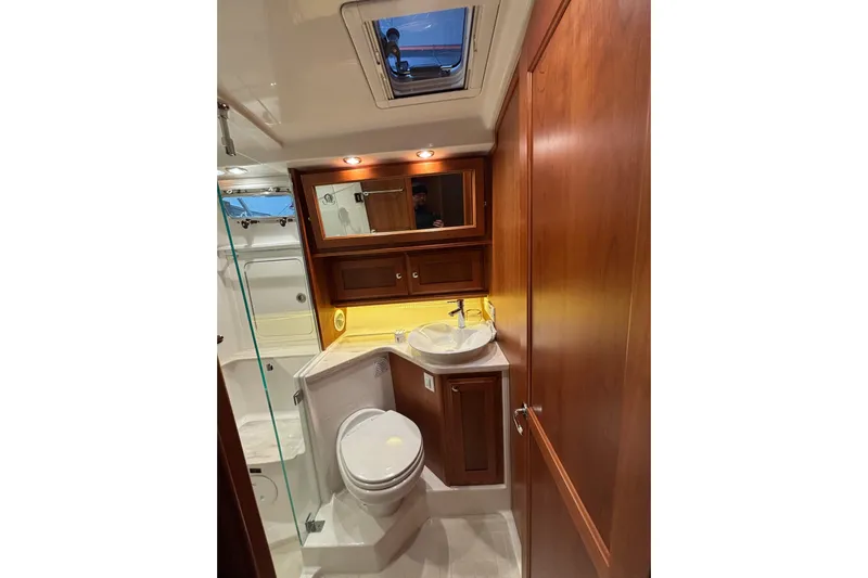 Cellibrate Yacht Photos Pics Luxurious bathroom in 2020 Sabre 45 Salon Express yacht with wood cabinetry and modern fixtures.