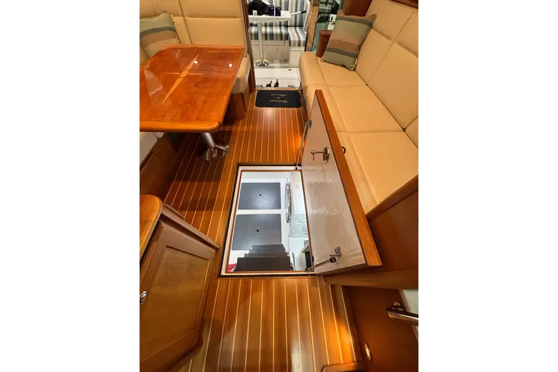 Cellibrate Yacht Photos Pics Interior of 2020 Sabre 45 Salon Express with open floor hatch and wooden furnishings.