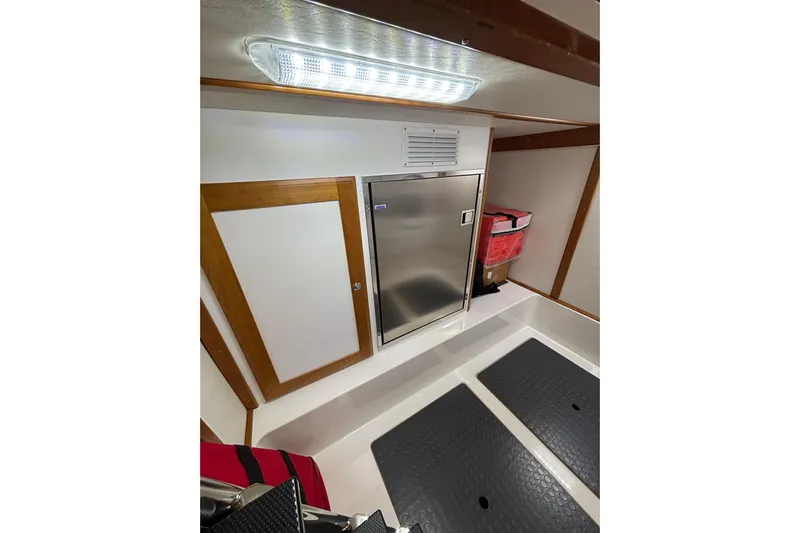 Cellibrate Yacht Photos Pics 2020 Sabre 45 Salon Express interior with stainless steel fridge and wooden accents.