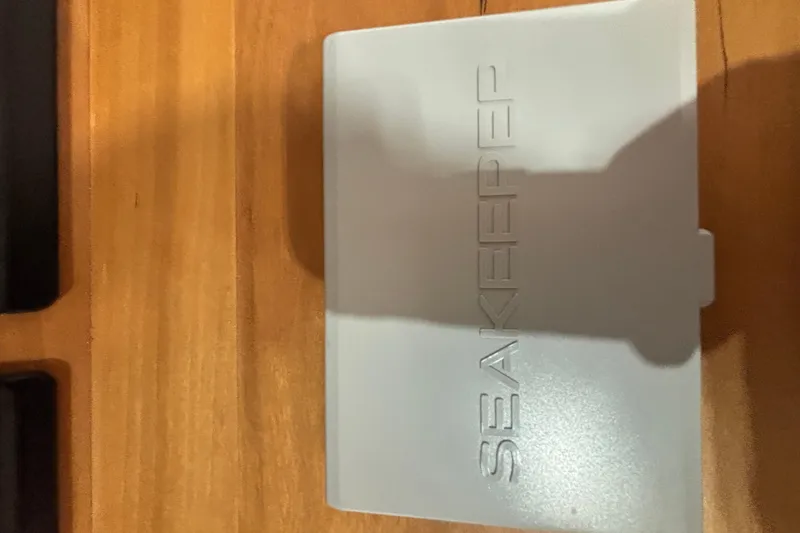 Cellibrate Yacht Photos Pics Seakeeper control panel on Sabre 45 Salon Express 2020, wooden surface background.