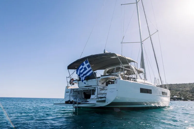 Euphoria Yacht Photos Pics 2021 Jeanneau 60 yacht sailing in clear blue waters with Greek flag.