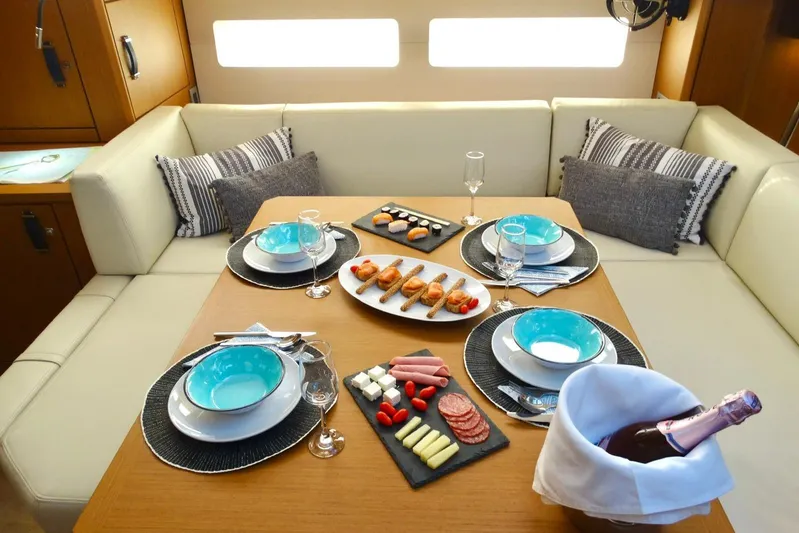 Euphoria Yacht Photos Pics Luxurious dining setup in Jeanneau 60 yacht, 2021 model, featuring elegant tableware and gourmet appetizers.